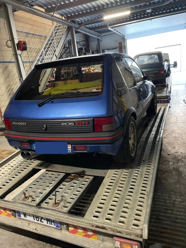 Peugeot 205 GTI sur un plateau de transport